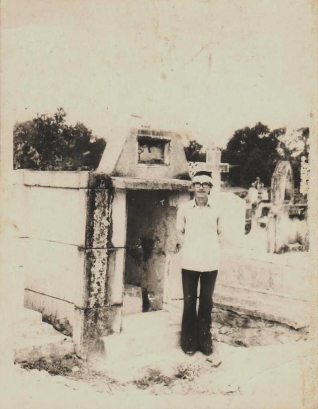 Chuẩn úy Hoàng Văn Soát đứng bên cạnh mộ phần của Cố Thiếu úy Hoàng Văn Soát. 