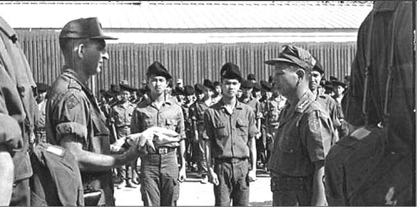 Đại diện quân lực Hoa Kỳ (trái) trao đổI Quốc Kỳ với Chỉ Huy Trưởng TSQ VNCH Nguyễn Văn Ưng (phải).